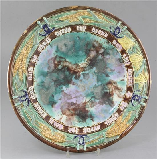 A Victorian majolica bread dish, late 19th century, with a motto, wheatsheaf and sickle border, unmarked, diameter 38.5cm